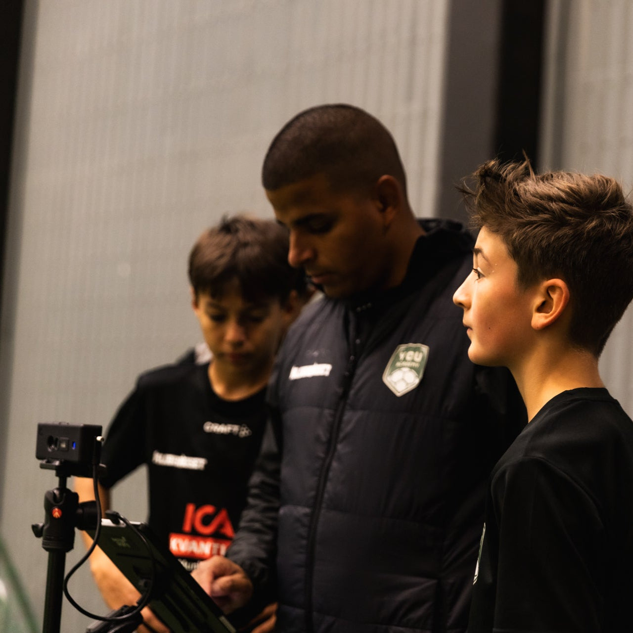 Group of young people in sports attire with a camera, possibly in a sports setting.