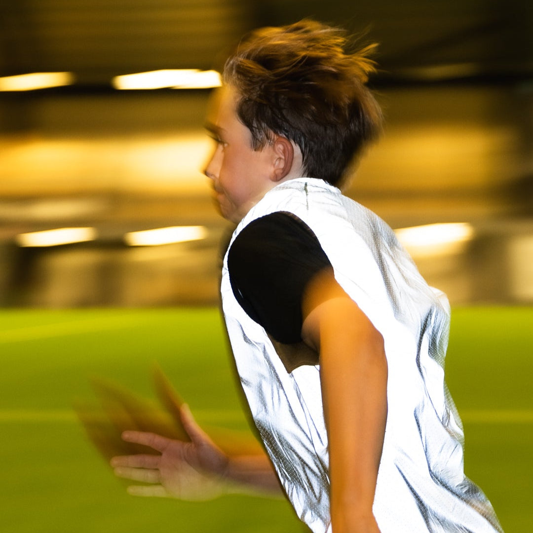Person playing soccer on a field with blurred lights in the background