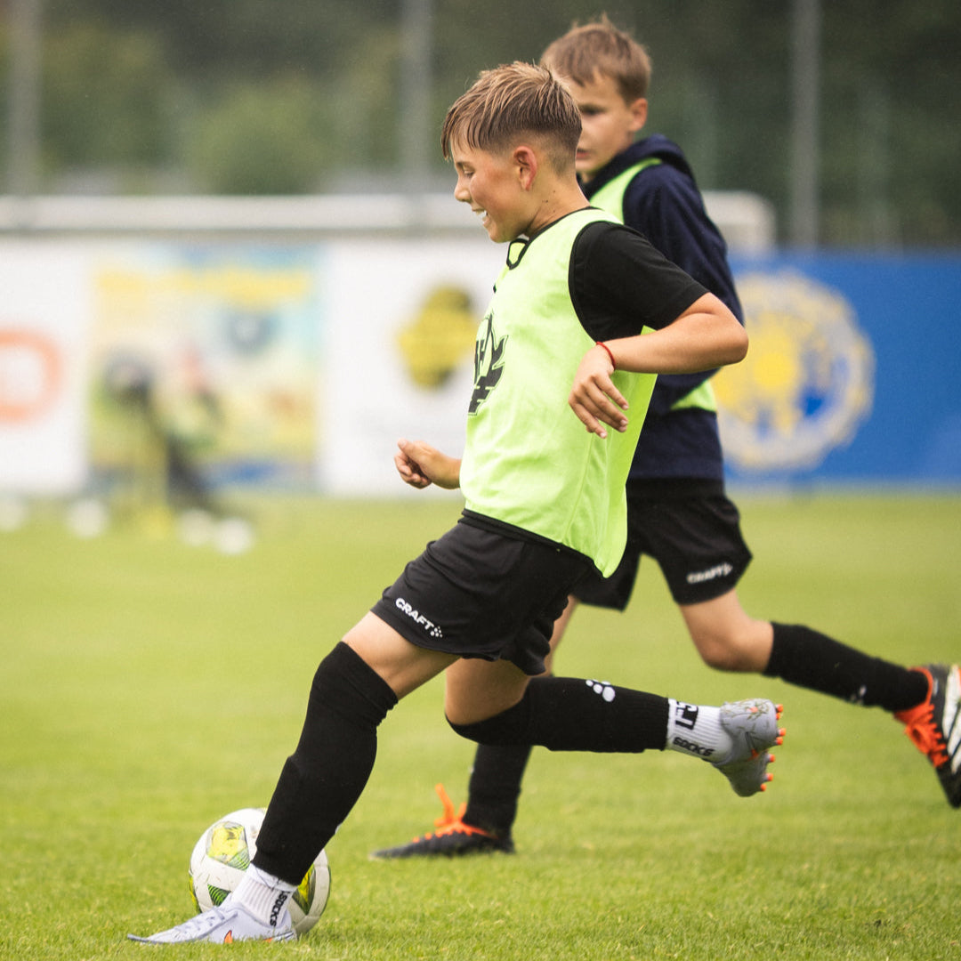 Two young soccer players on a field with a blurred background
